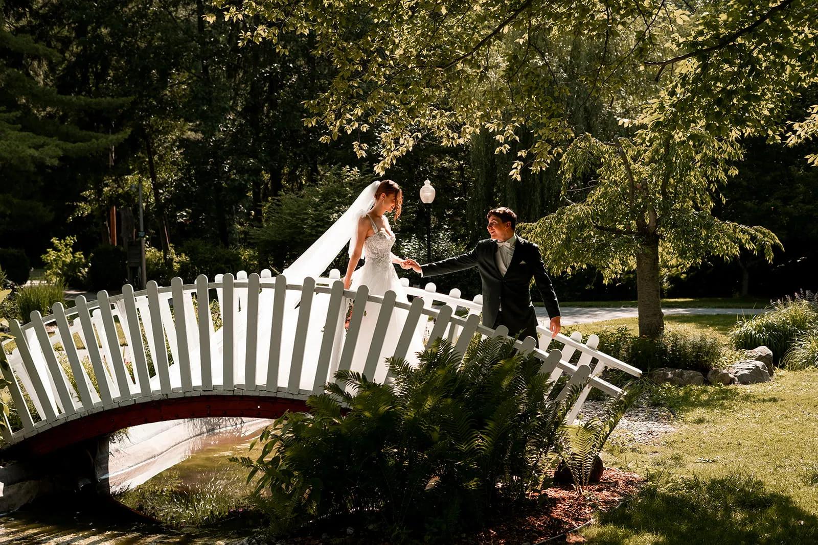 bride and groom photo in a garden on a bridge